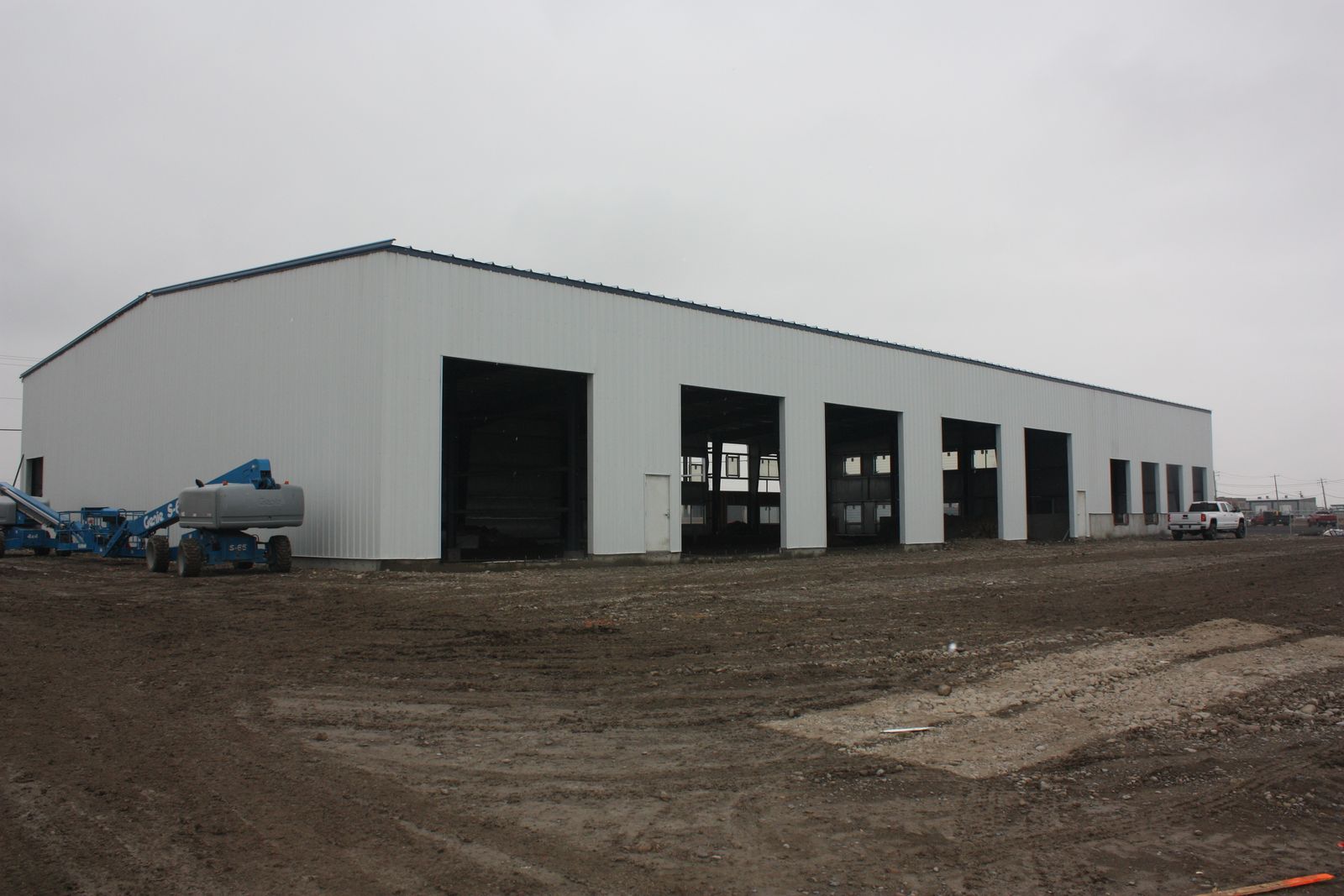 White steel industrial building with several overhead doors